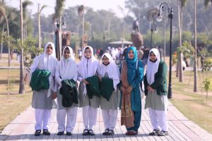 Students and teacher from Shakarganj Evergreen School standing together during an educational outing in a public park.